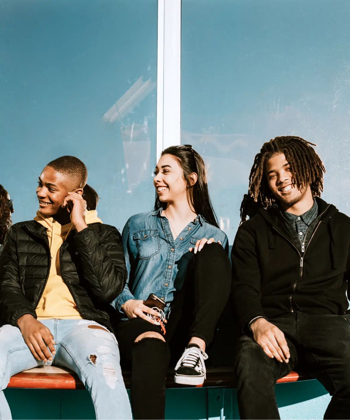 Trois jeunes assis côte à côte, souriants