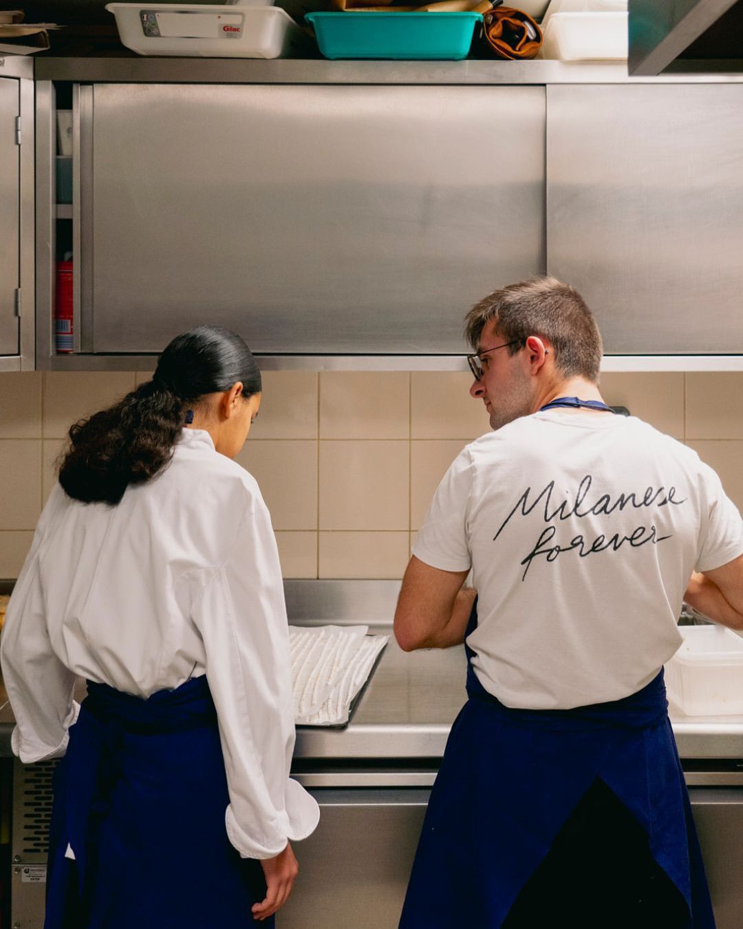 Deux personnes en tenue de cuisine dans une cuisine professionnelle
